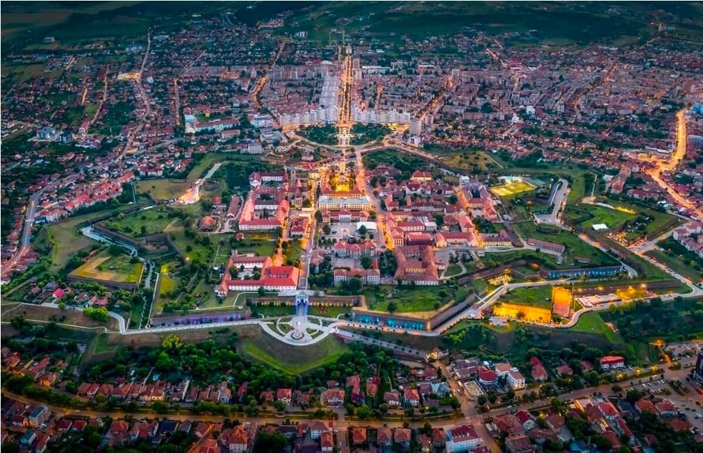 Aerial view of the star-shaped Alba Carolina citadel lit up at dusk, Alba Iulia